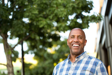 Happy mature African American man smiling outside.