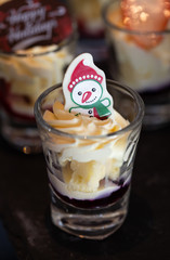 Sweet dessert cheese cake with blueberry topping with snowman white chocolate in a glass