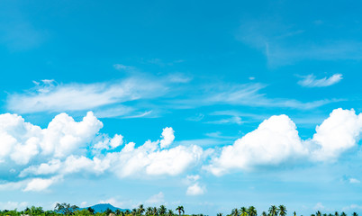 Plakat Beautiful blue sky and white cumulus clouds against coconut tree and mountain in happy and chill out day. While away time on tropical summer vacation concept. Background for summer travel. Cloudscape.
