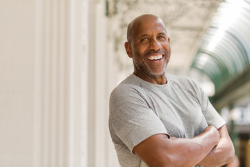 Happy mature African American man smiling outside.