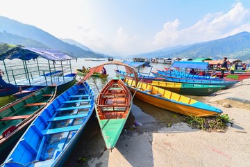 Fototapeta na wymiar Scenery of Colourful Rowboats on Phewa Lake in Pokhara, Nepal