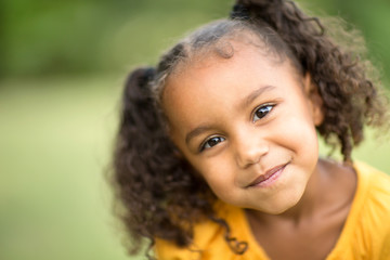 Cute mixed race little girl laughing and smiling.