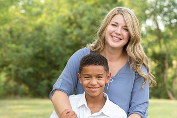 Mother and son laughing and playing at the park.