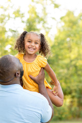 Father laughing and playing with his daugher.