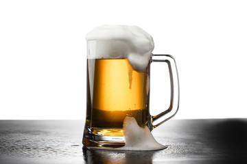 Frosty mug of light beer on wood table