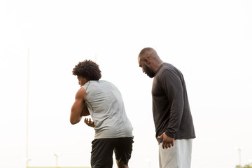 American Football coach training a young athlete.