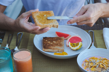 young man on holiday in a tropical island eating a healthy breakfast