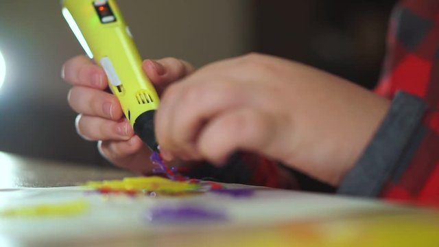 Extra Close-up Teen Boy Uses A 3D Pen. He Creates A 3D Figure From Plastic.