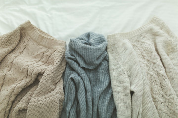 Flat lay autumn and winter fashion photography. Stylish women outfit. Brown knitted sweaters and gray turtleneck. Trendy comfy clothes