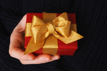 rotes Geschenk Päckchen wird in einer Hand gehalten