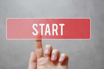 Start - hand pressing red transparent button on virtual touchscreen interface on grey background...