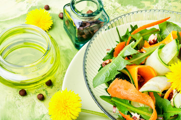 Fresh salad with dandelions flowers,cucumber, arugula and carrot.Healthy vegan lunch bowl