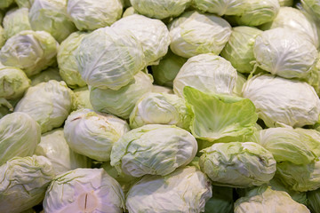 Fototapeta na wymiar Group of green cabbages in a supermarket. Green cabbage pile on sale in supermarket, healthy cabbages, fresh cabbages are good for health