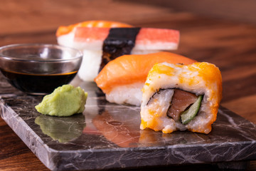 Sushi Set sashimi and sushi rolls served on stone slate