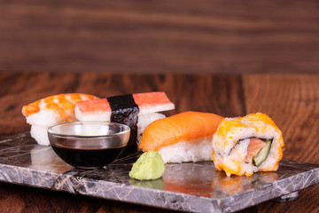 Sushi Set sashimi and sushi rolls served on stone slate