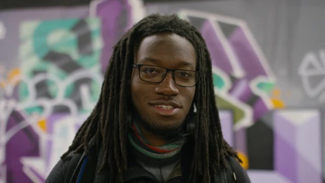 Portrait of smiling black male with dreadlocks looking to camera 