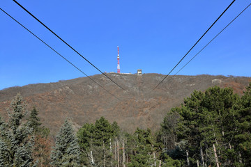 Obraz premium Red and white cell tower on iron pylons against a blue sky