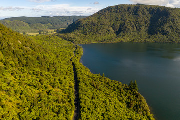 Blue and Green lake country forest road, Rotorua, New Zealand. Aerial POV