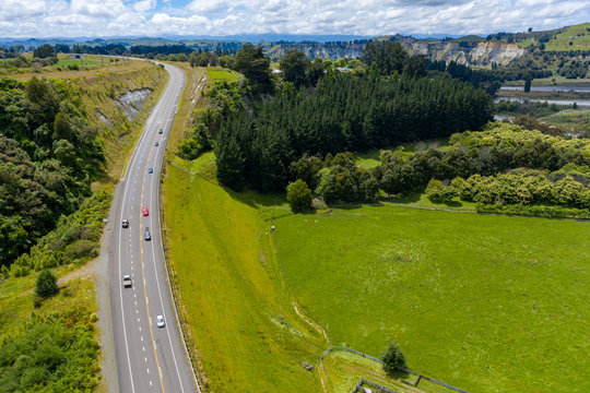 Cars traveling on SH1 road through New Zealand countryside 