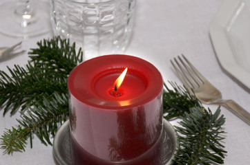 Colorful red Christmas candle with pine foliage