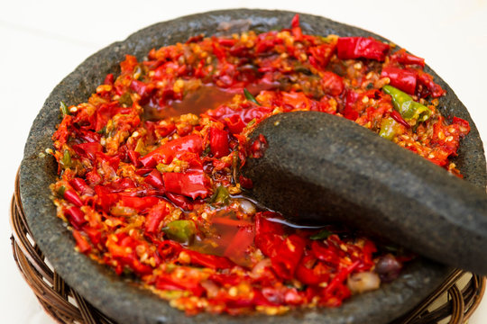 Grinding chili in a traditional stone grinder or sambal ulek