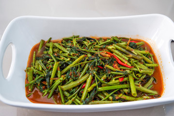 Indonesian food tumis kangkong terasi or stir fry swamp cabbage