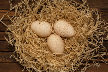 Group of three fresh turkey eggs on a wooden table