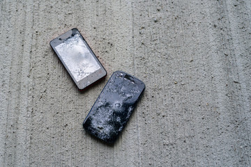 Broken phones on concrete