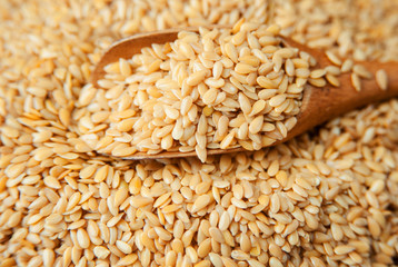 Wooden spoon with golden flax seeds. Close-up