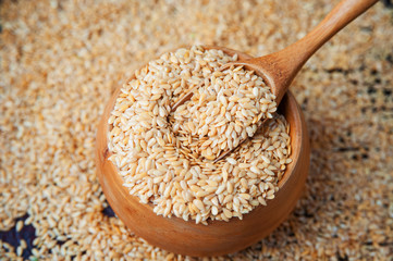 Golden flax seeds in wooden bowl.