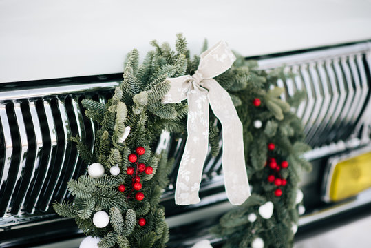 Classic christmas wreath on  retro car. Holiday car wreath. Retro car decorated with christmas wreath for holidays.