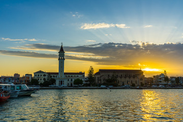Fototapeta premium Greece, Zakynthos, Intense colors of orange sunset sky over beautiful zante city and harbor
