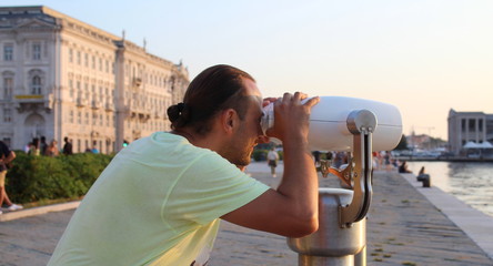 Turista che ammira il panorama col binocolo