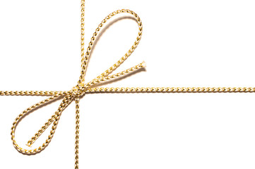 Golden satin rope with knotted bow gift ribbon wrap for Christmas present with intricate shine details isolated cut out on simple plain white background.