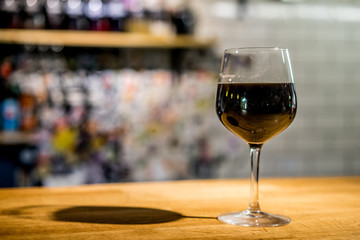 Glass of Stout Beer in oversized wine glass on the bar counter
