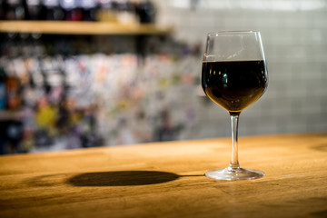 Glass of Stout Beer in oversized wine glass on the bar counter