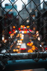 New York city bokeh lights from cars, view through the metal fence
