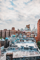 Graffiti on Manhattan Buildings, rooftop, skyscraper and cloudy blue sky