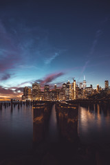 Lower Manhattan skyline scenic view from Brooklyn Bridge Park in New York City during sunset, East River side