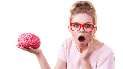 Shocked woman in eyeglasses holding human brain