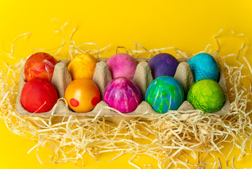 colorful, hand-painted, pastel Easter eggs on a bright, yellow, spring background