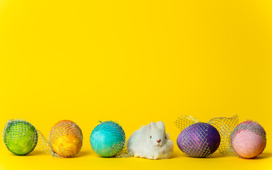 colorful, hand-painted, pastel Easter eggs on a bright, yellow, spring background