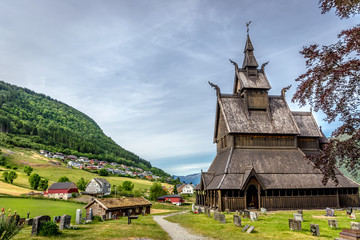 A wood church in a green grass field in Norway