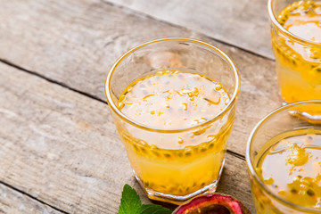 Passion fruit - Passion fruits half and juice with mint on the vintage wooden background.