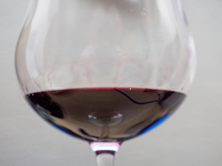 Closeup detail of a Burgundian wine glass filled with a French aged red wine. Shallow focus. Bangkok, Thailand. Culture and cuisine.