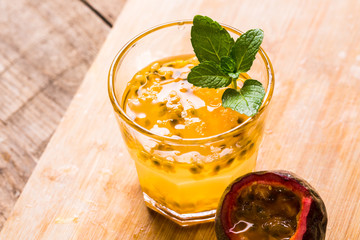 Glass of fresh passion fruit with mint on table
