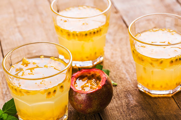 Passion fruit - Passion fruits half and juice with mint on the vintage wooden background.