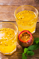 Passion fruit - Passion fruits half and juice with mint on the vintage wooden background.