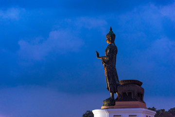 Obraz premium large bronze statue of Buddha standing on an outdoor platform