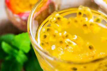 Glass of fresh passion fruit with mint on table